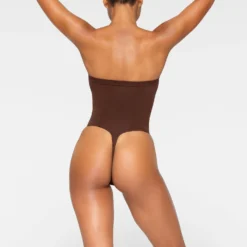 SEAMLESS SCULPT STRAPLESS THONG BODYSUIT | COCOA 9 SEAMLESS SCULPT STRAPLESS THONG BODYSUIT | COCOA -SWIM Sales Store SKIMS SHAPEWEAR BD THG 2913 JA COA 0060 BK
